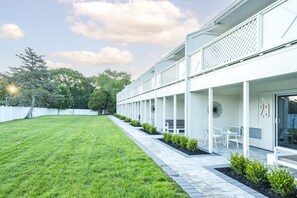 A modern building with a covered outdoor seating area and a well-maintained lawn. - The Bentley Hotel Southampton (Southampton)