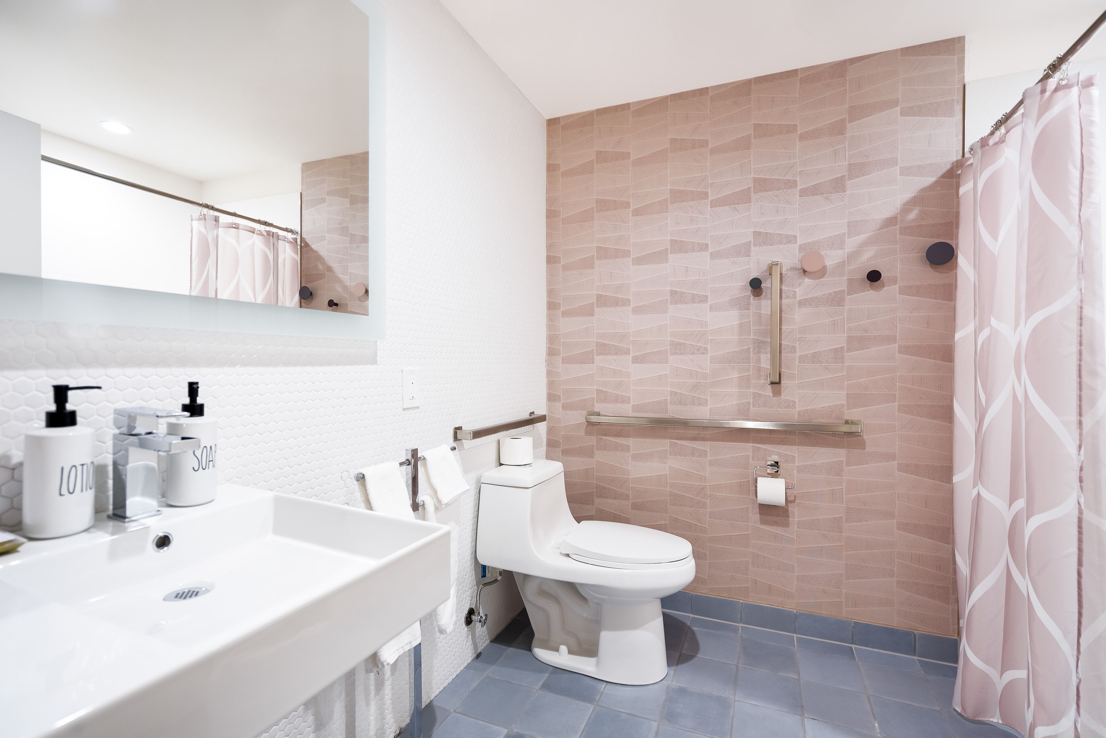 Un baño moderno con lavamanos, inodoro y ducha blancos.