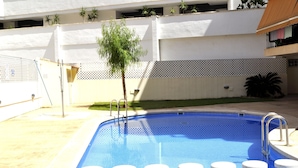 A swimming pool with a tiled edge, a metal ladder, and several steps leading into the water. - El Forti, 2 bedrooms, center, by Bookindenia (Dénia)