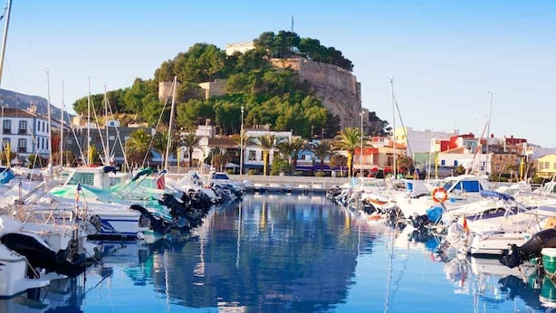 A marina with boats docked, a prominent hill with buildings on top, and a clear sky. - El Forti, 2 bedrooms, center, by Bookindenia (Dénia)