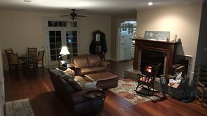 Ein Wohnzimmer mit Kamin, einer Couch, einem Couchtisch und einem Essbereich mit Stühlen.