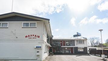 A motel with a sign reading "MAYFAIR COURT MOTEL" and a "VACANCY" sign.