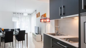 Una cucina moderna con mobili scuri, un lavello in acciaio inossidabile e un forno integrato.