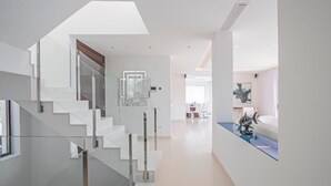 A modern interior with a staircase, a dining area, and a decorative fish tank. - A truly exceptional villa (Xàbia)