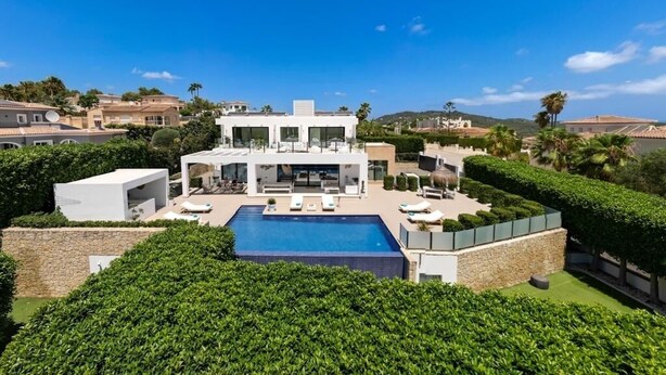 A modern villa with a swimming pool, surrounded by well-maintained hedges and a clear blue sky. - A truly exceptional villa (Xàbia)