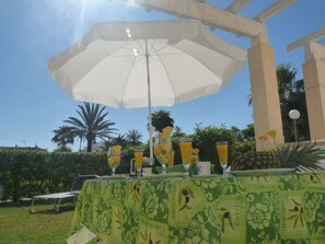 Enjoy a meal under the shade of an umbrella in a tropical setting.