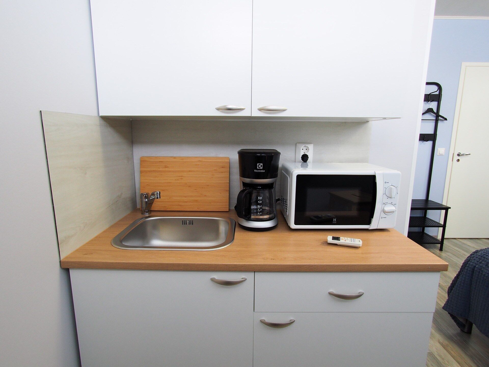 A compact kitchenette with a sink, a coffee maker, and a microwave.