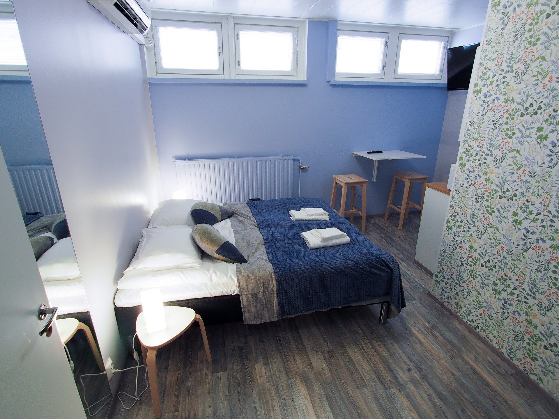 Una habitación con cama, escritorio, silla y radiador.