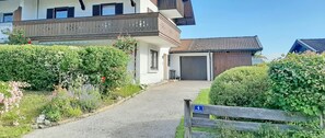 Ein zweistöckiges Haus mit Balkon, Garage und gepflegtem Garten.