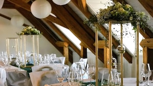 A banquet hall with tables set for a formal event, featuring tall centerpieces with greenery and flowers. - Swiss Hotel La Couronne (Avenches)