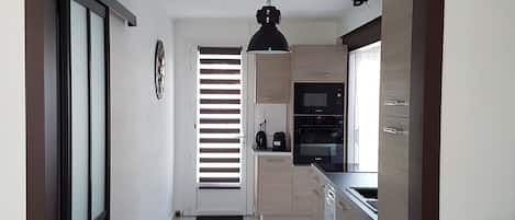 A modern kitchen with a microwave, oven, and coffee maker.