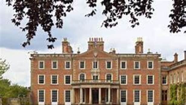 A large, symmetrical brick building with a central entrance, multiple windows, and a well-maintained lawn in front. - 3 Bed Broomfield Road Newport Shropshire (Newport)