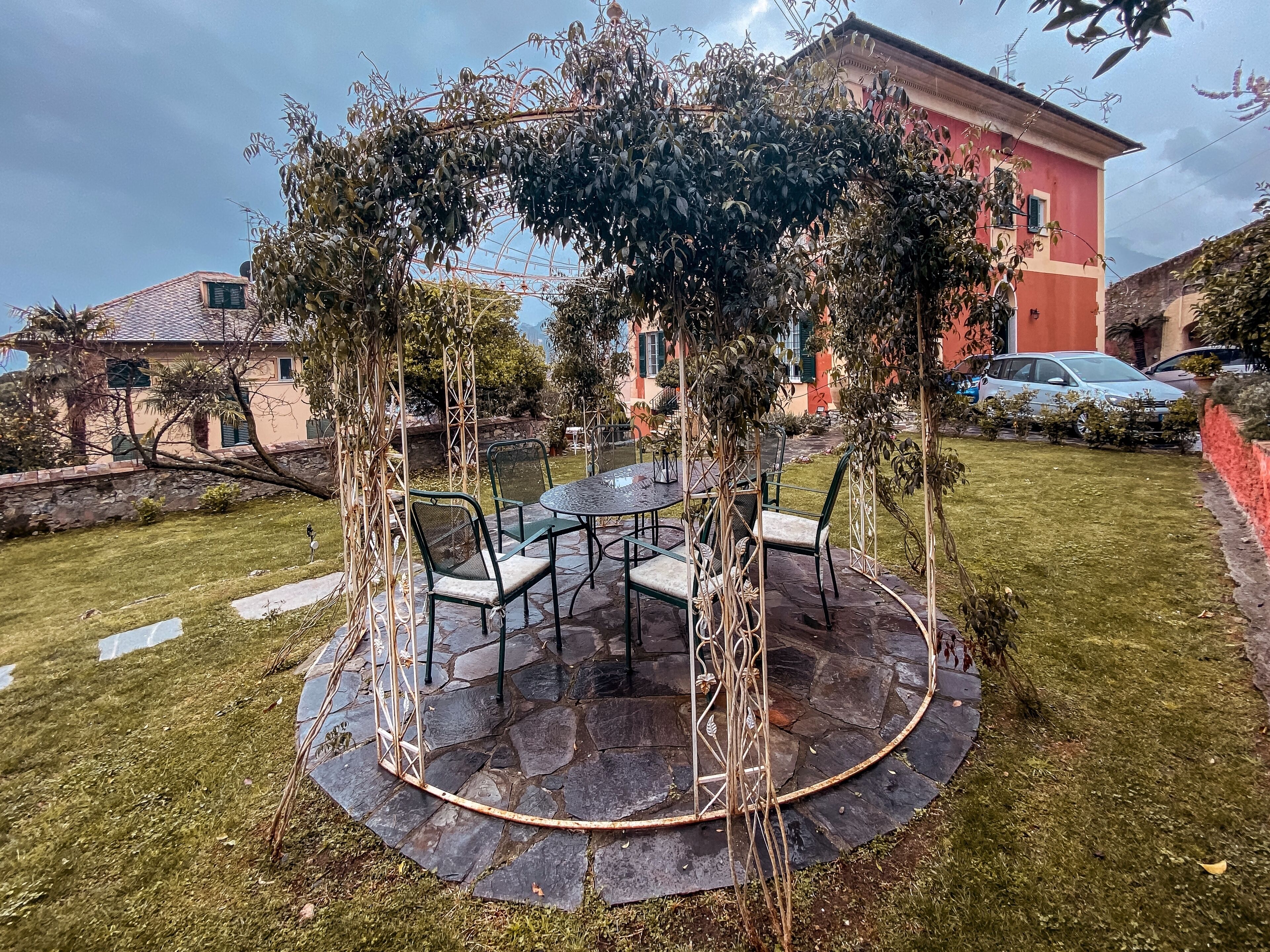 A circular outdoor seating area with a table and chairs, surrounded by a stone patio.