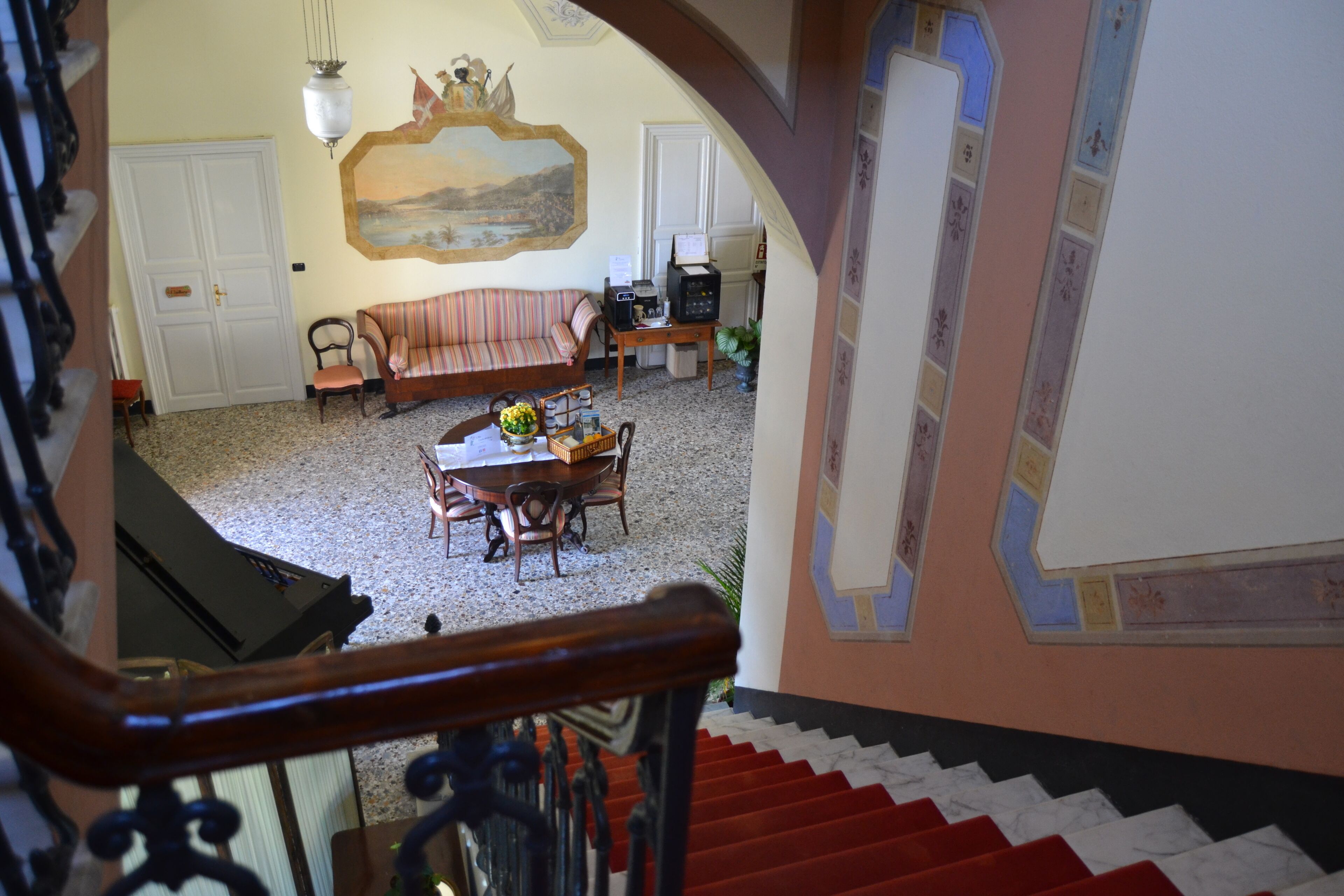 Un escalier menant à un espace repas comprenant une table et des chaises, un canapé et un téléviseur.