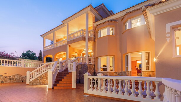 A large, multi-story house with a prominent staircase, multiple balconies, and a well-lit exterior. - Luxury villa with sea view, with Swimming pool (Campello)