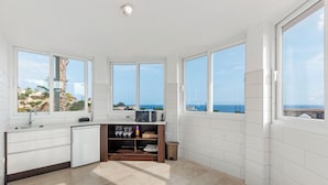 A compact kitchen with a view of the sea, a microwave, and a small refrigerator. - Luxury villa with sea view, with Swimming pool (Campello)