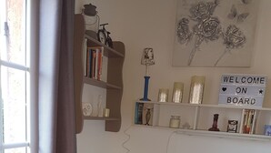A cozy room with a bed, a bookshelf, and a welcome sign. - Petit Fleur Studio with Terrace (Ampus)