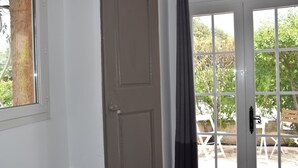 A room with a door leading to an outdoor area with a table and chairs. - Petit Fleur Studio with Terrace (Ampus)
