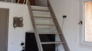 A staircase leading to a loft area with a television mounted on the wall. - Petit Fleur Studio with Terrace (Ampus)