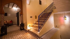 Un escalier orné de rampes en métal décoratives et doté de carreaux de sol à motifs.