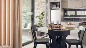 Eine moderne Küche mit integriertem Mikrowellenherd, einem großen Fenster und einem Essbereich mit rundem Tisch und Stühlen.