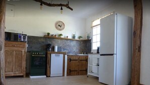 A kitchen with a refrigerator, oven, dishwasher, and wooden cabinets.