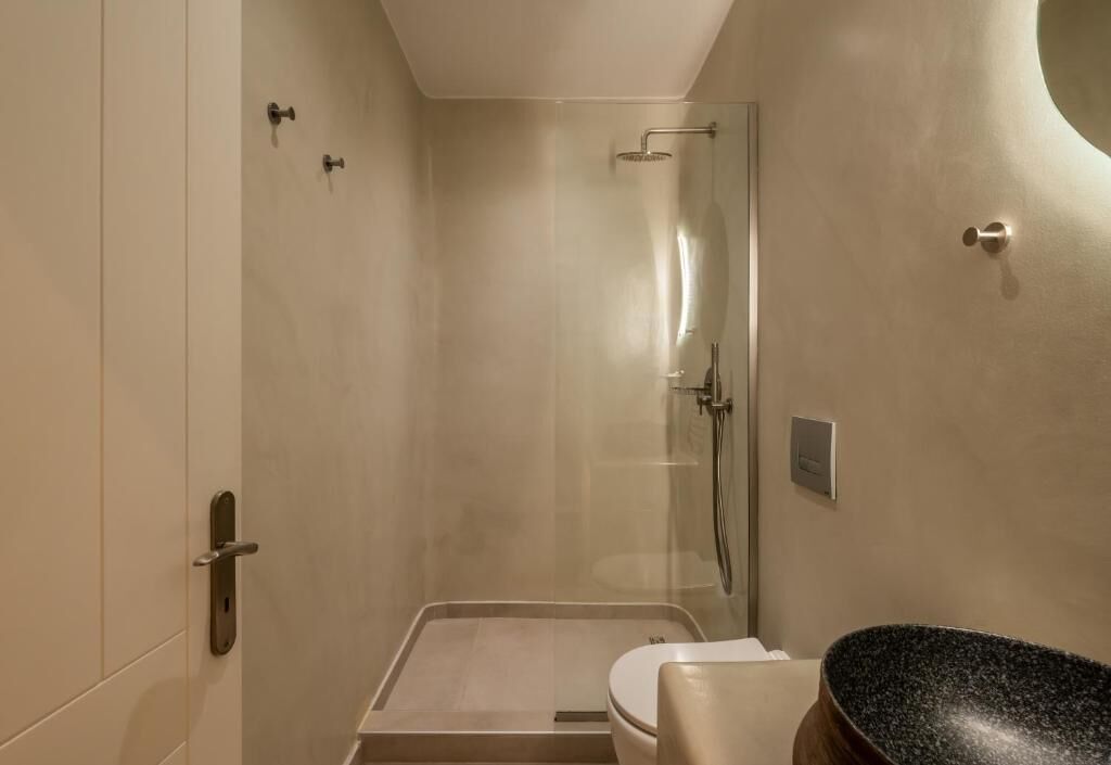 Un baño moderno con ducha, inodoro y lavamanos.