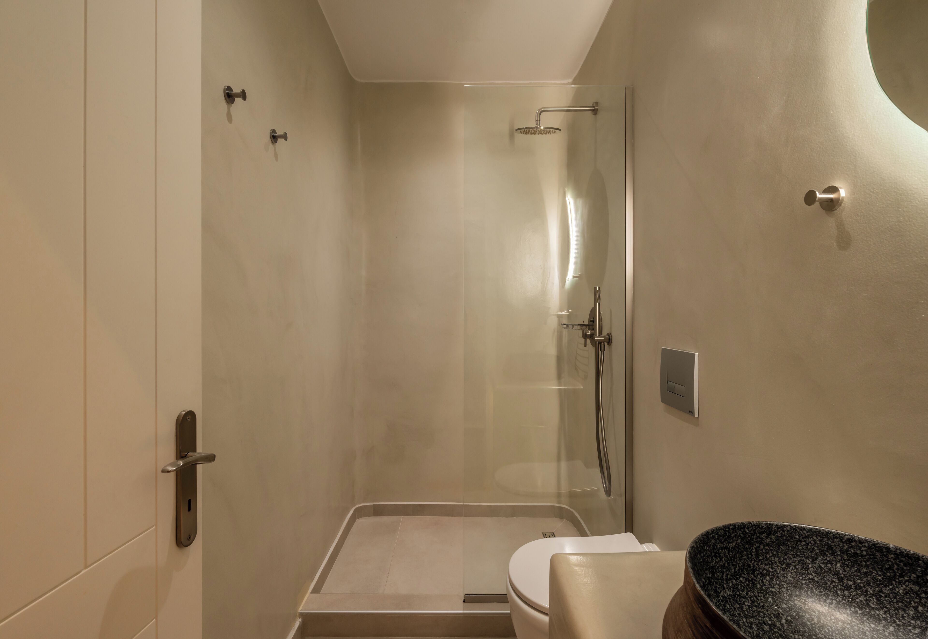 Une salle de bain moderne avec une douche à parois de verre, des toilettes et un lavabo en granit.