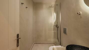 Une salle de bain moderne avec une douche à parois de verre, des toilettes et un lavabo en granit.