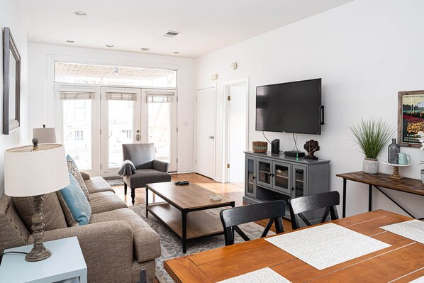 Relax in this stylish living room with a sofa set, coffee table, and dining table, perfect for unwinding with a view.