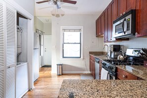 Enjoy cooking in this well-equipped kitchen with a stainless steel refrigerator, oven, and microwave.
