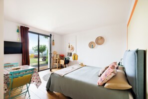 A bedroom with a bed, a table, and a chair.