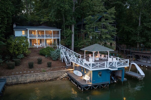 Une propriété située au bord de l’eau, dotée d’un quai, d’un espace salon abrité et d’une maison avec balcon.