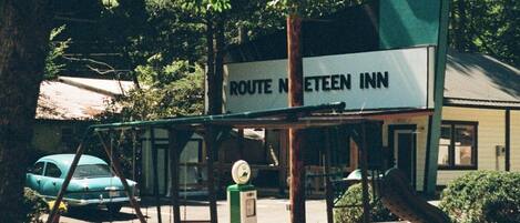 A Route 19 Inn sign with a swing set and a car in the background.