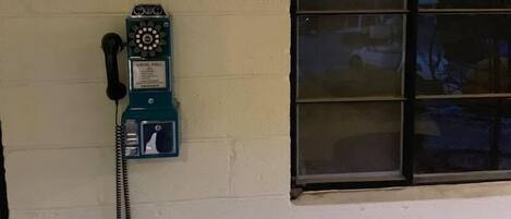 A public telephone with a sign above it that reads "PUBLIC TELEPHONE."