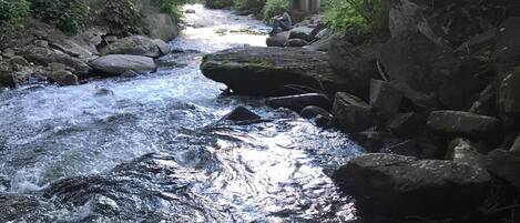 Un río serpenteando por una zona boscosa, con un puente al fondo.