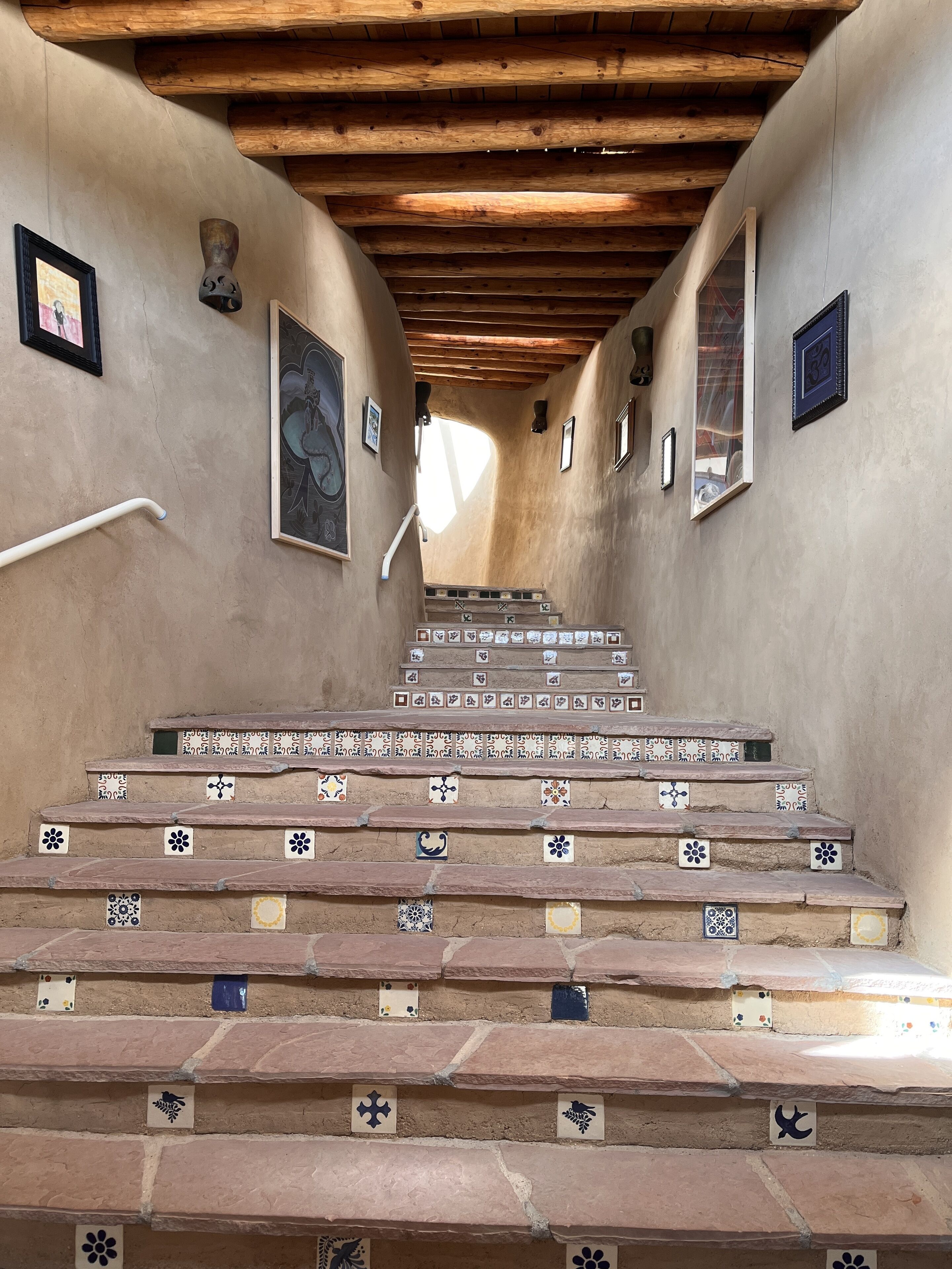 Una escalera con baldosas estampadas y vigas de madera.