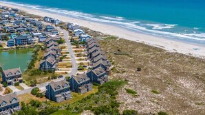 A coastal residential area with houses along the beach and a road leading to the ocean. - Slow Motion | Community Beach Access + Pool! (Topsail Beach)