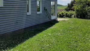 A large, single-story house with a sloped roof and a small porch. - Beautiful vacation home in a quiet location (Mönchneversdorf)