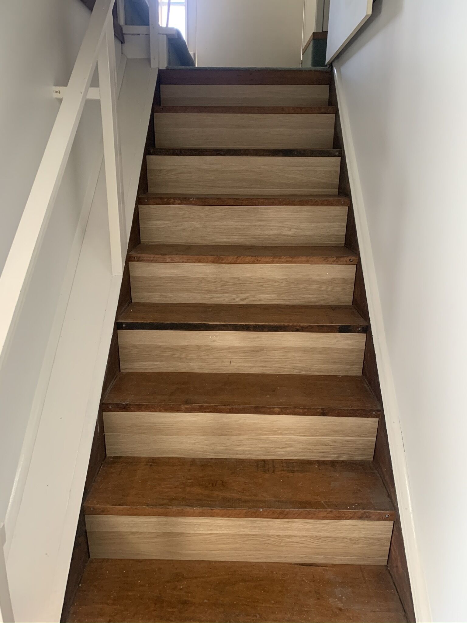 Una escalera de madera con barandillas blancas.