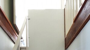 A wooden staircase with white handrails and a white wall at the top. - Catalina Coastal Getaway / Family friendly home (Catalina)