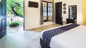 Un dormitorio con cama, escritorio, silla, armario y ventana con cortinas.