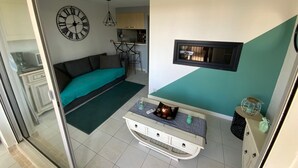 A compact living space with a sofa, a small dining area, and a kitchenette. - T2 air-conditioned apartment with swimming pool close to grande plage richelieu (Agde)