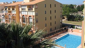 A hotel with a swimming pool, a terrace with lounge chairs, and a view of the surrounding area. - T2 air-conditioned apartment with swimming pool close to grande plage richelieu (Agde)