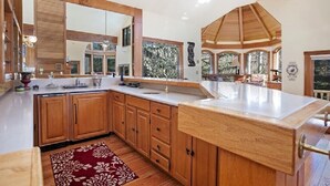 Una cocina amplia con armarios de madera, una isla grande y vistas al exterior.