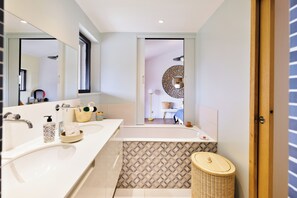 A modern bathroom with two sinks, a large mirror, and a patterned tile backsplash. - Spacious BAÏGURA studio, mountain views, direct access to pool & spa (Hasparren)