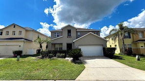 A residential area with houses, a driveway, and a clear sky.