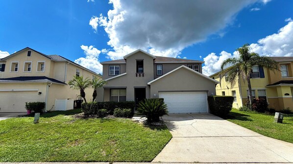 A residential area with houses, a driveway, and a clear sky.