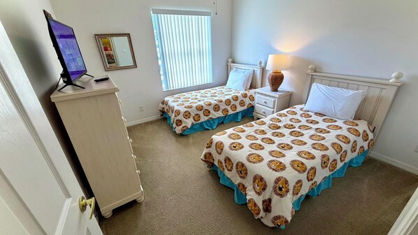 A bedroom with two beds, a desk, a lamp, and a window with blinds. - Charming Pool Home, with game room. 15 minutes from Disney parks. (Davenport)