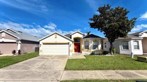 A residential area with houses, a driveway, and a well-maintained lawn.